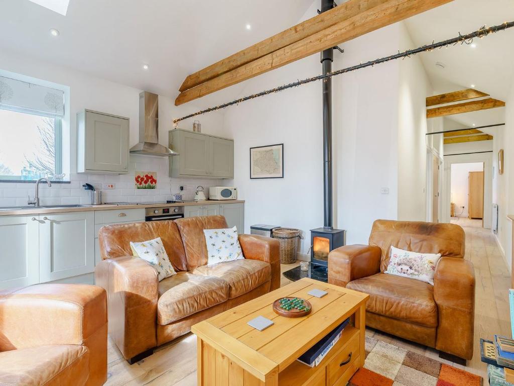 uma sala de estar com dois sofás e uma mesa em Abigails Cottage em Trimdon Grange