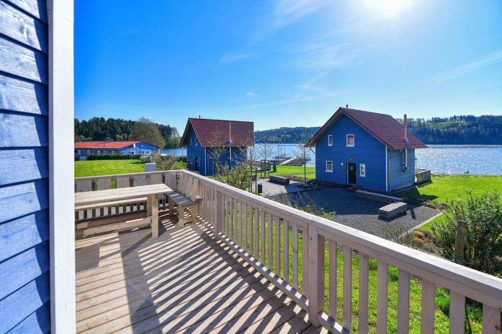 una terraza con vistas al agua y a las casas en Nordic Ferienpark Sorpesee (Sauerland) en Sundern