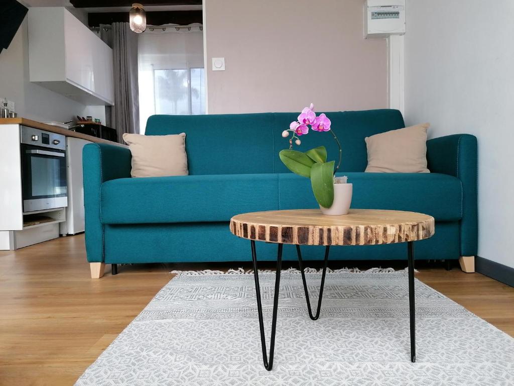 a living room with a blue couch and a table at Le Langka in Saint-Louis