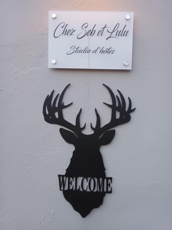 een bord met een hertenkop op een muur bij Chez Seb & Lulu, studio d'hôtes in Neufchâteau