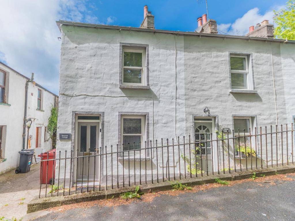 una casa blanca con una valla delante en Beeswax Cottage, en Dalton-in-Furness