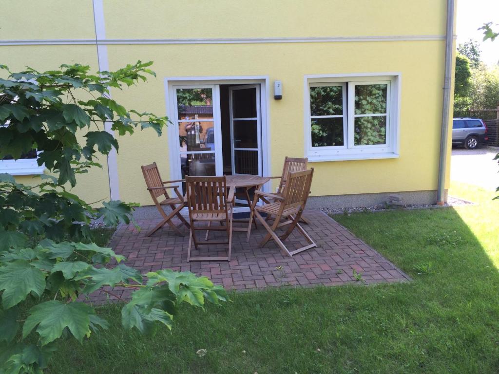 eine Terrasse mit einem Tisch und Stühlen vor einem Haus in der Unterkunft Chico in Graal-Müritz