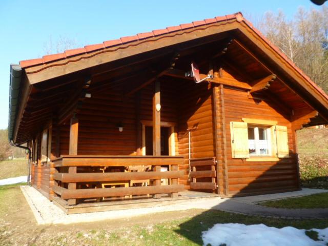 eine Blockhütte mit einer Veranda und einem Fenster in der Unterkunft Blockhaus mit WLAN Bayern in Stamsried