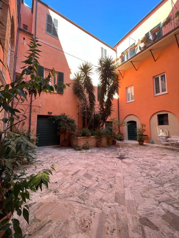 un cortile di un edificio arancione con palme di B&B letterario Palazzo Pistocchi a Teramo