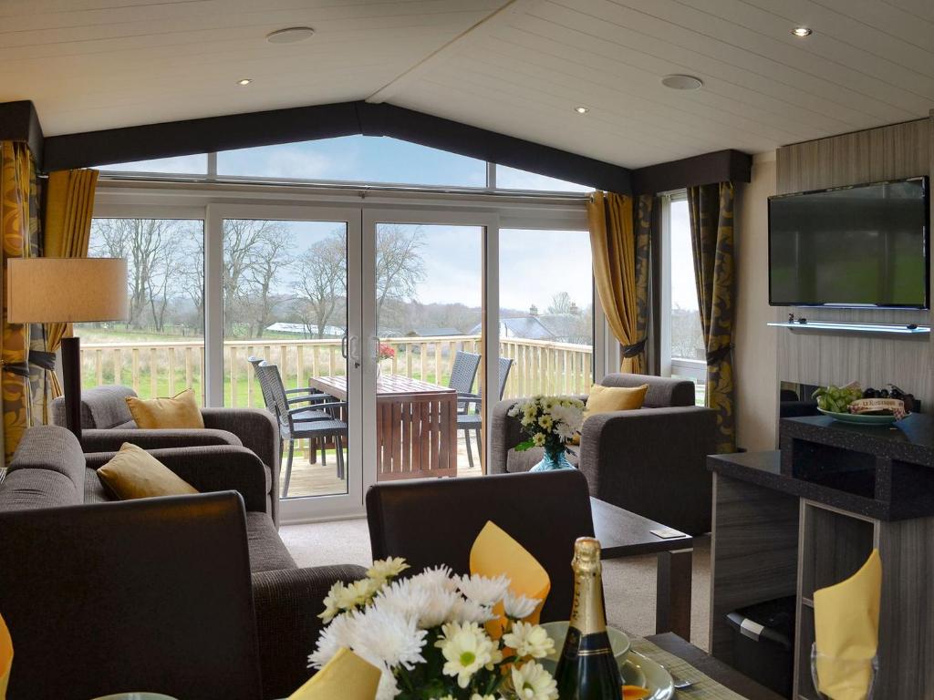 a living room with couches and a television and a table at Skylark Lodge in Westward