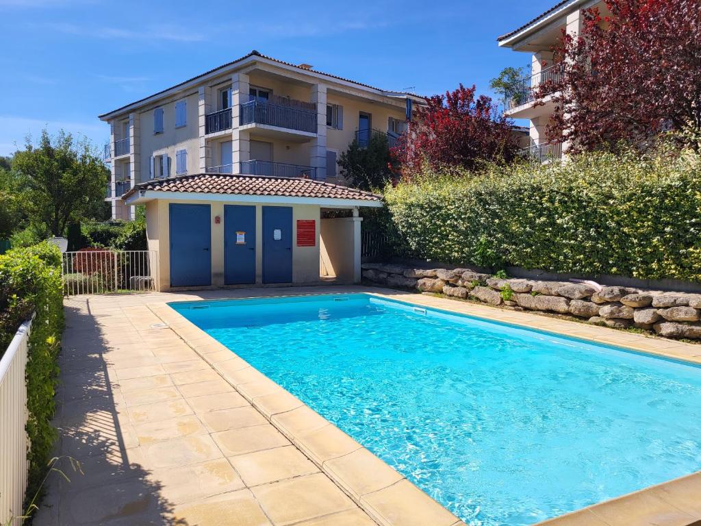 a swimming pool in front of a house at Le Pietra in Uzès