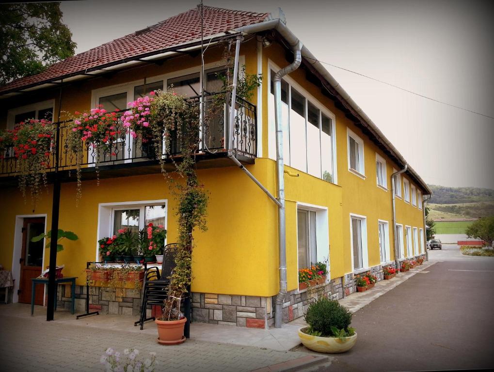 um edifício amarelo com uma varanda e flores nele em Cazare La Troita em Codlea