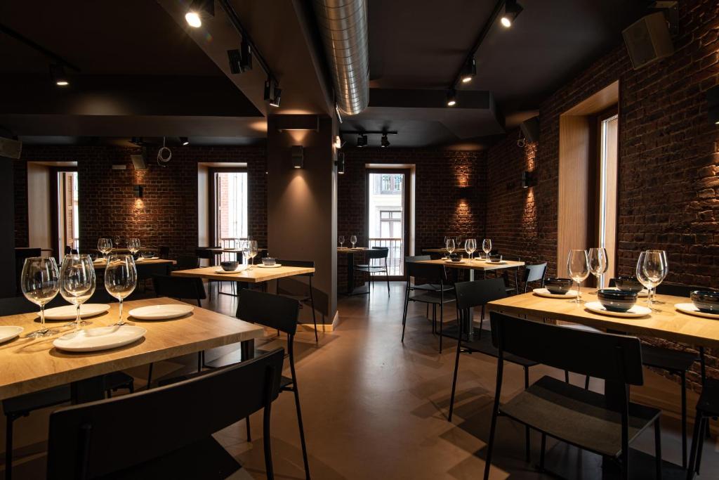 a restaurant with wooden tables and chairs with wine glasses at Hotel Atari in Donostia-San Sebastián