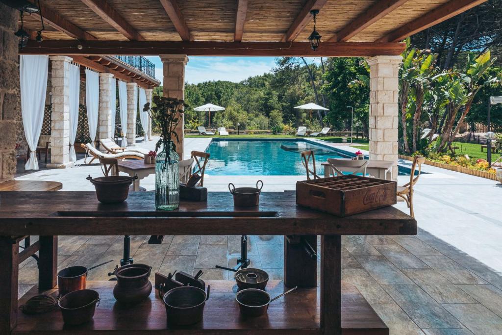 a table with pots on it in front of a pool at Antica Villa Colonica in Sorso