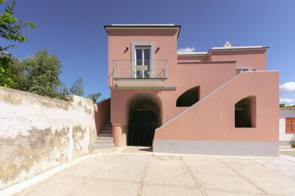 una casa rosa con balcone e scala di Sea More a Procida