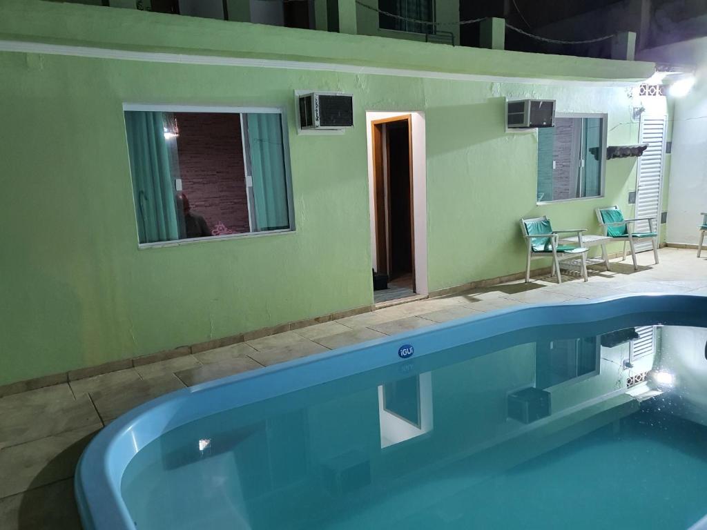 una grande piscina in una stanza verde con di O mais lindo pôr do sol ad Arraial do Cabo