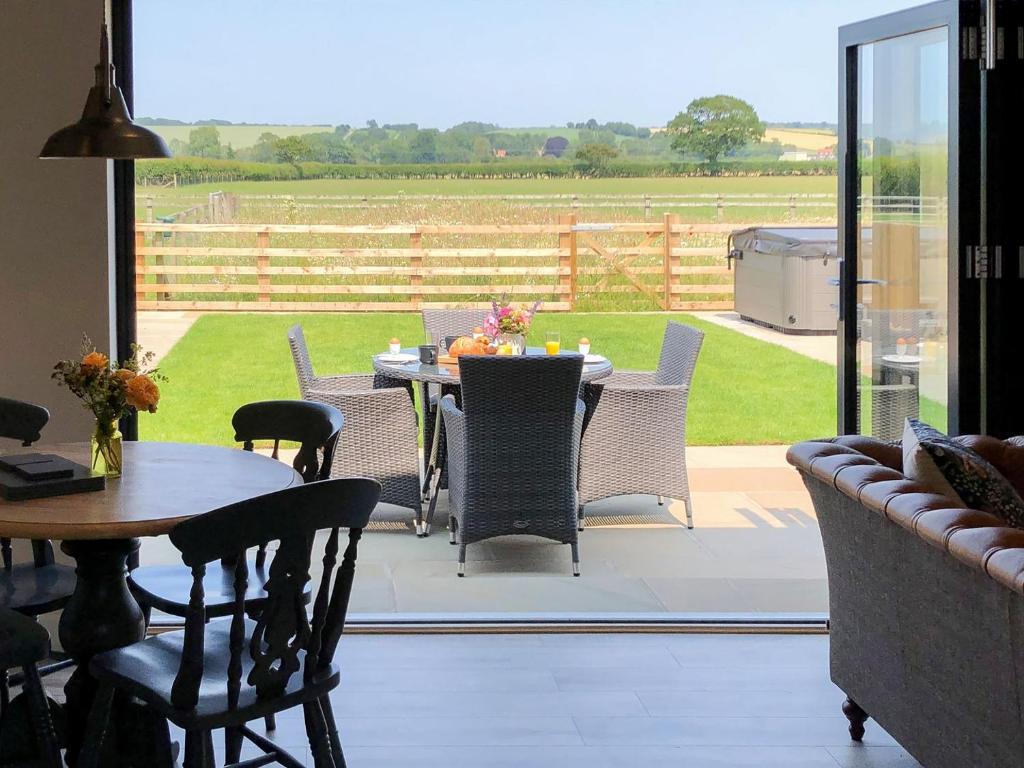 a patio with a table and chairs and a view of a field at The Old Dairy - Uk31253 in Middleton