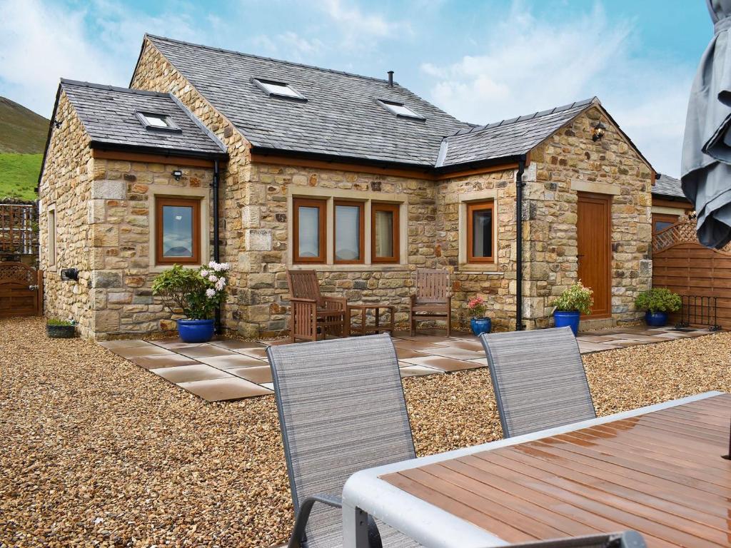 a stone cottage with a table and chairs in front of it at Hen House - Uk31827 in Rimington