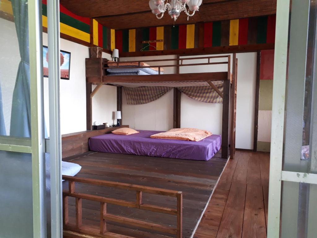 名護市にあるbackpackers guesthouse Borderの二段ベッド2台とテーブルが備わる客室です。