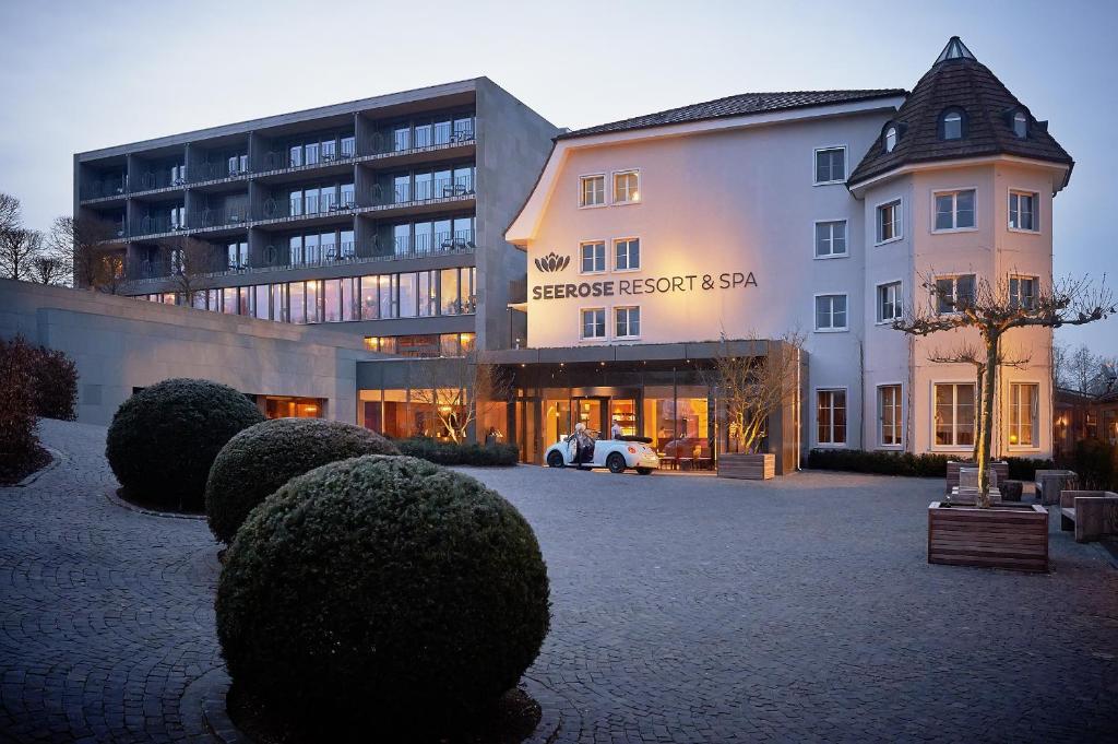 budynek z mnóstwem krzaków przed nim w obiekcie Seerose Resort & Spa w mieście Meisterschwanden
