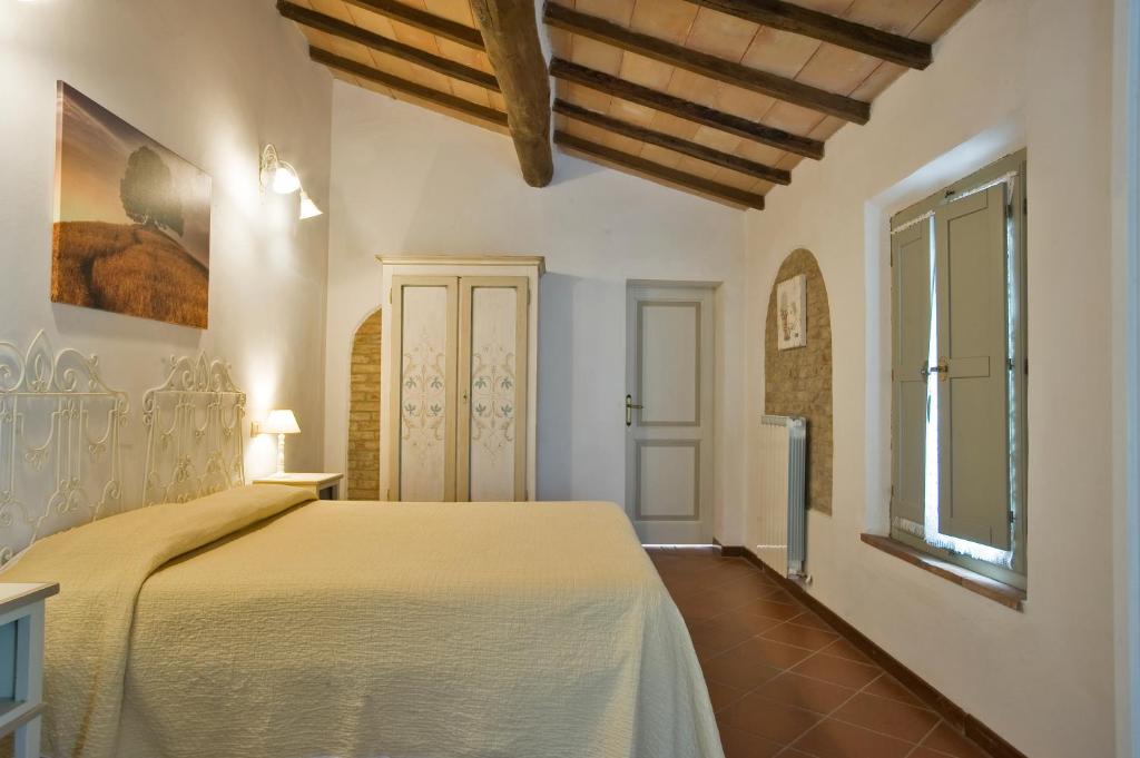 1 dormitorio con cama y ventana en Podere San Giuseppe Montalcino, en Montalcino