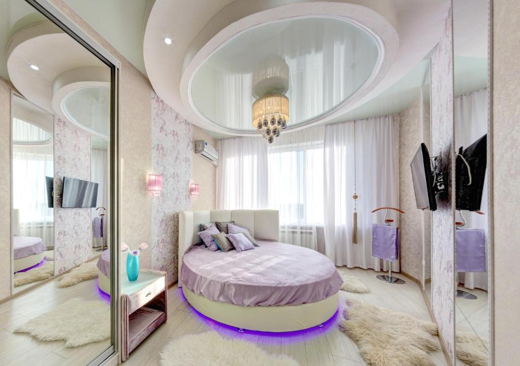 a bedroom with a bed in a room with a mirror at InnHome Apartments in Chelyabinsk
