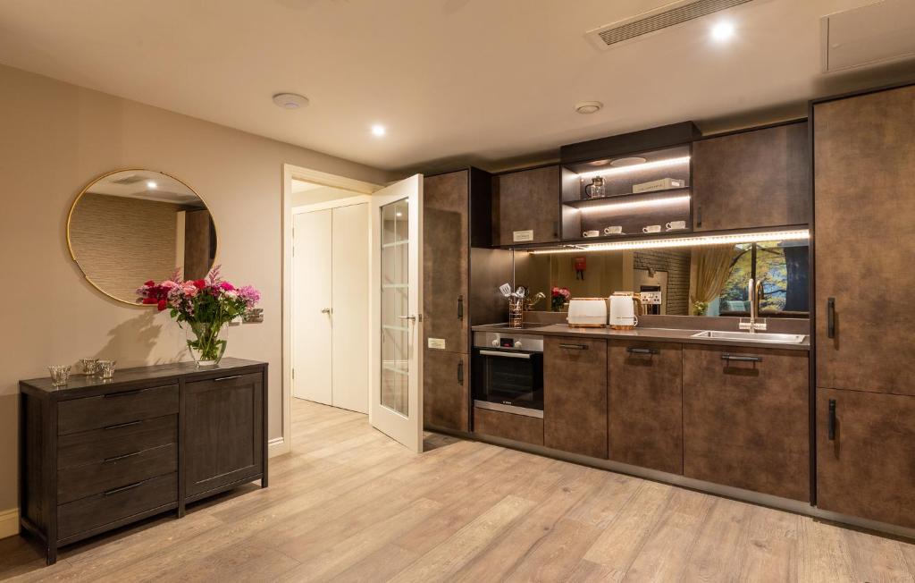 a large kitchen with wooden cabinets and a sink at The Lawrance Luxury Aparthotel - York in York