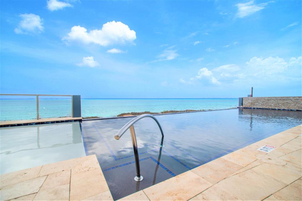 a swimming pool with the ocean in the background at Lighthouse Point Residences in West Bay