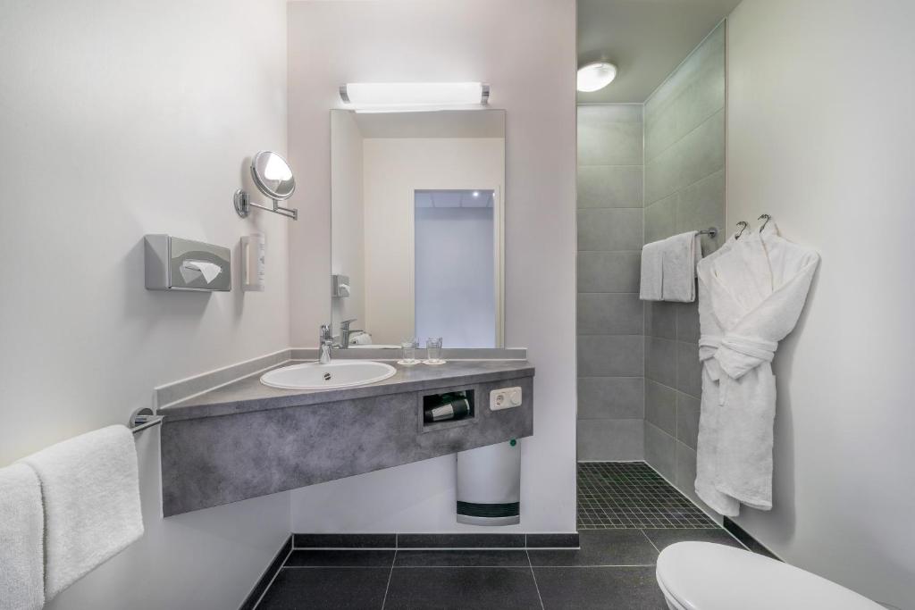 オーバーハウゼンにあるHotel Oberhausen Neue Mitte affiliated by Meliáの洗面台とトイレ付きのバスルーム