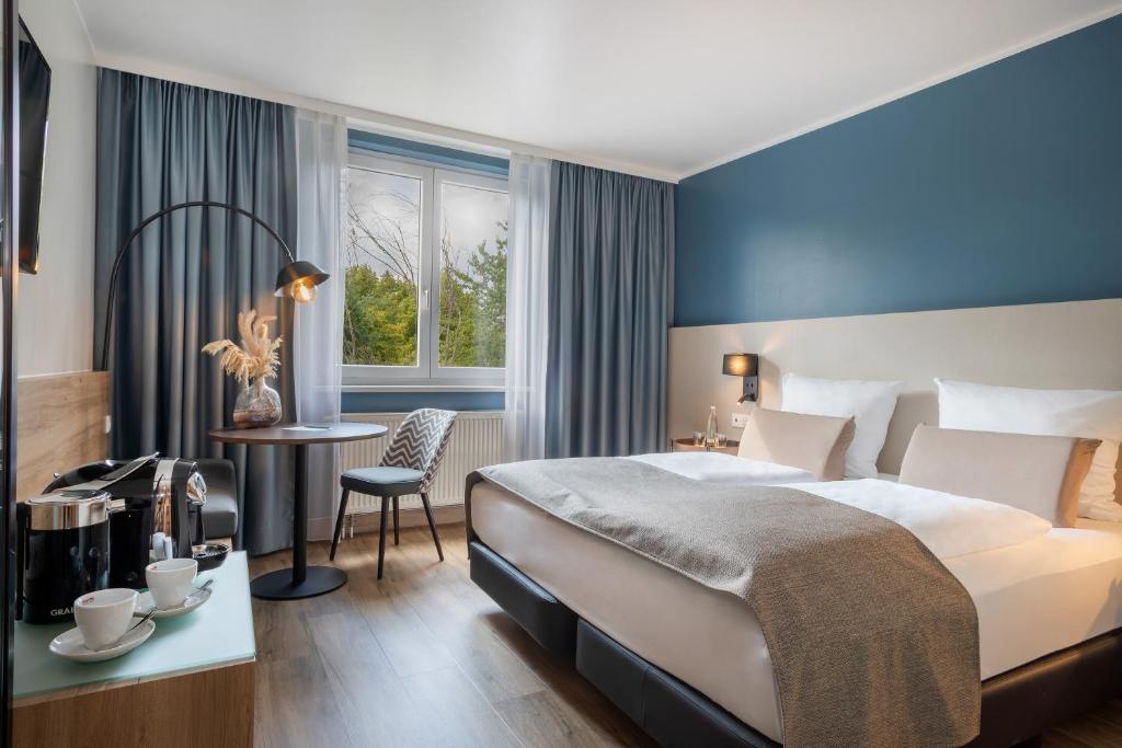 ein Hotelzimmer mit einem Bett, einem Tisch und einem Stuhl in der Unterkunft Hotel Oberhausen Neue Mitte affiliated by Meliá in Oberhausen