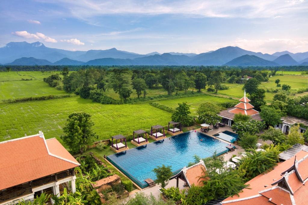 an aerial view of a pool at a resort with mountains in the background at Sriwilai Sukhothai in Sukhothai