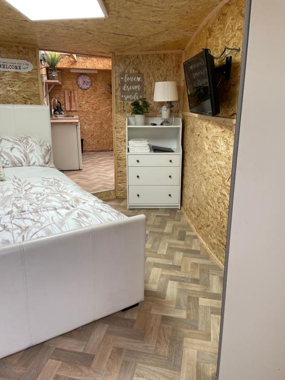 een slaapkamer met een wit bed en een keuken bij Pen-Y-Bryn Annex in Brynmenin