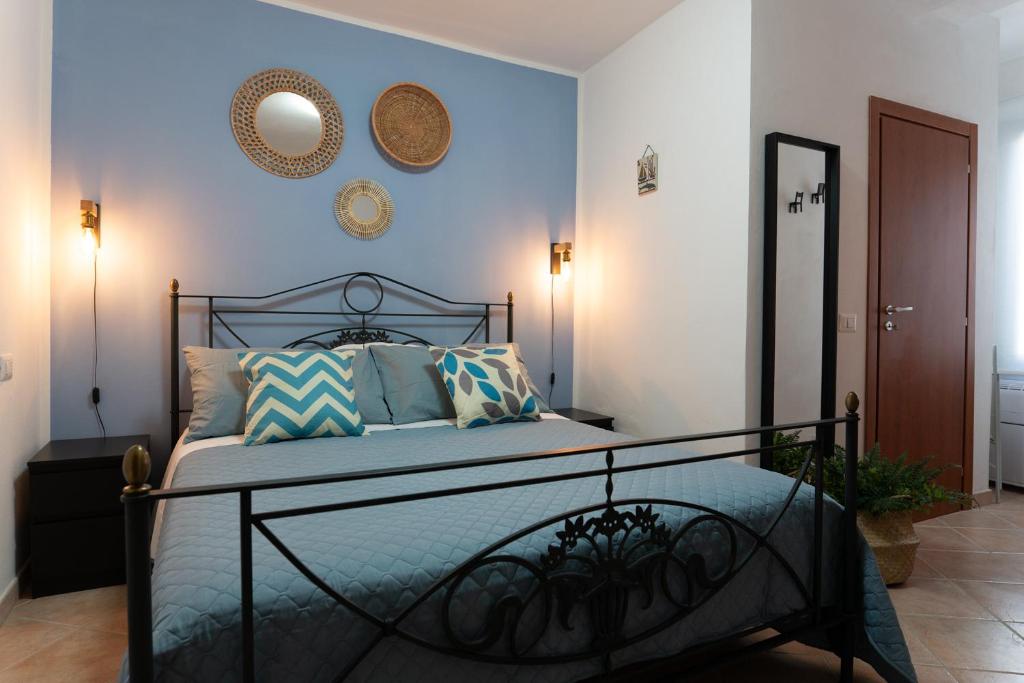 een slaapkamer met een bed met blauwe muren en een spiegel bij Residenza della Laguna in Orbetello