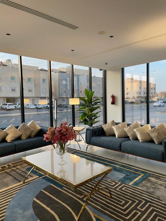 uma sala de estar com sofás e uma mesa com flores em شرفة em Riade