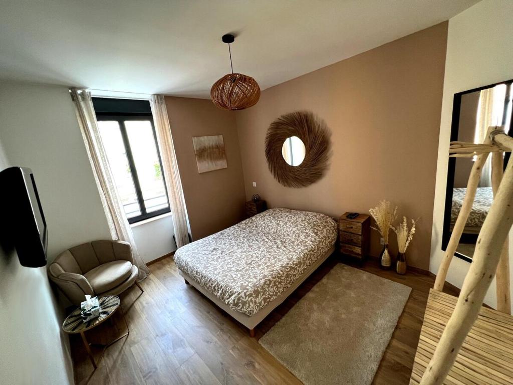 1 dormitorio con cama, silla y espejo en Belle chambre cosy, proche centre-ville et gare en Colmar