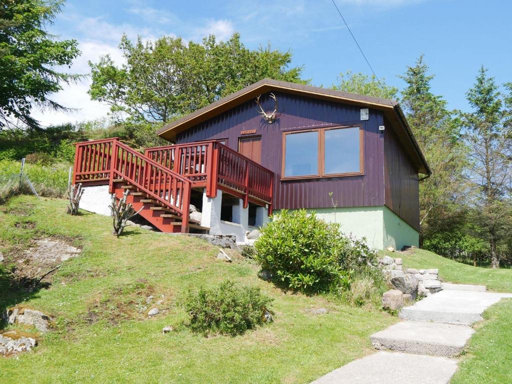 una casa morada con terraza en una colina en Assynt Chalet - Uk30806 en Lochinver