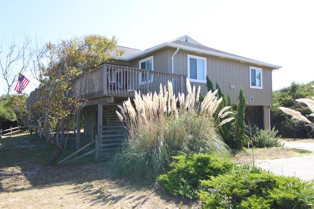 une maison avec un balcon et un drapeau américain dans l'établissement Summersalt, à Southern Shores