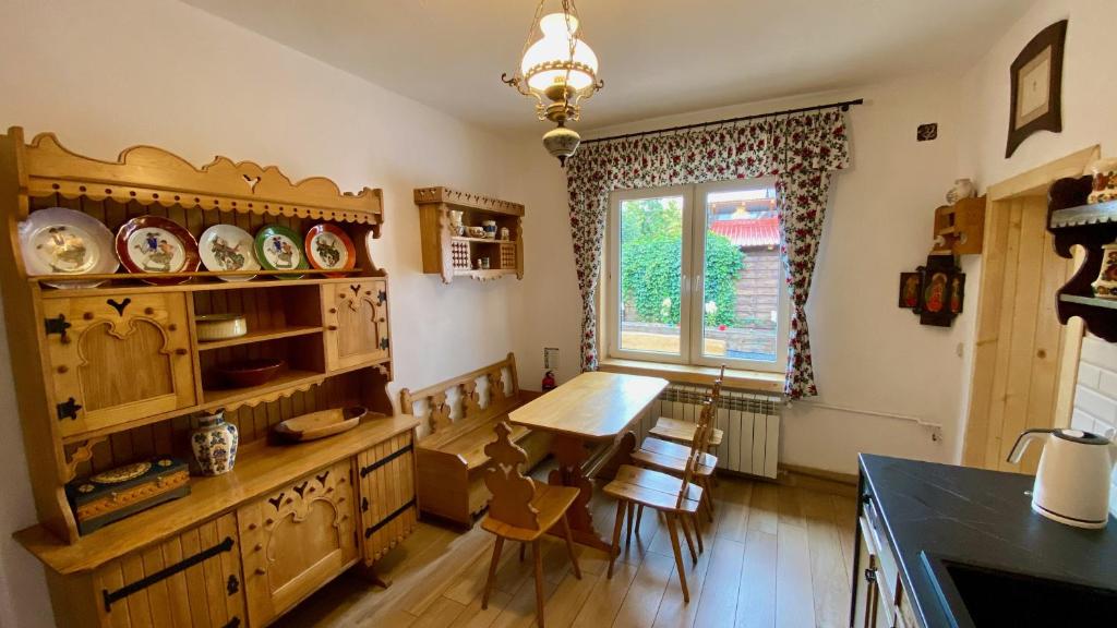 a kitchen with a table and a dining room at Helenówka - dom w stylu góralskim in Szczawnica