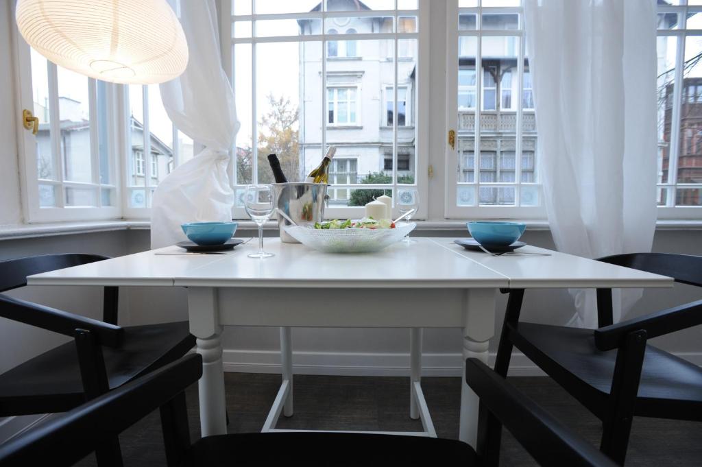 ソポトにあるSopot Special Apartmentsの白いテーブルと椅子、食べ物の盛り合わせ