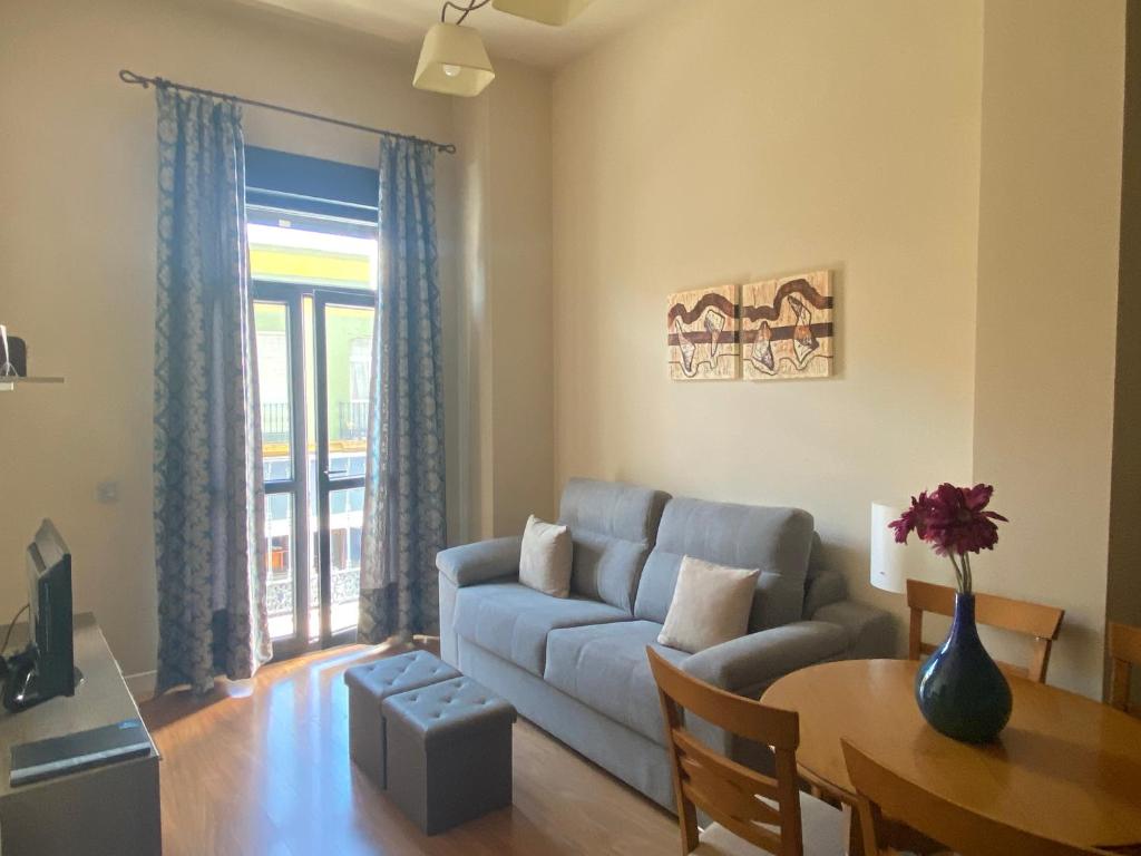 uma sala de estar com um sofá e uma mesa em SEVITUR Seville Comfort Apartments em Sevilha