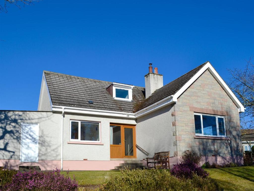 a white house with an orange door at Wester Links in Fortrose