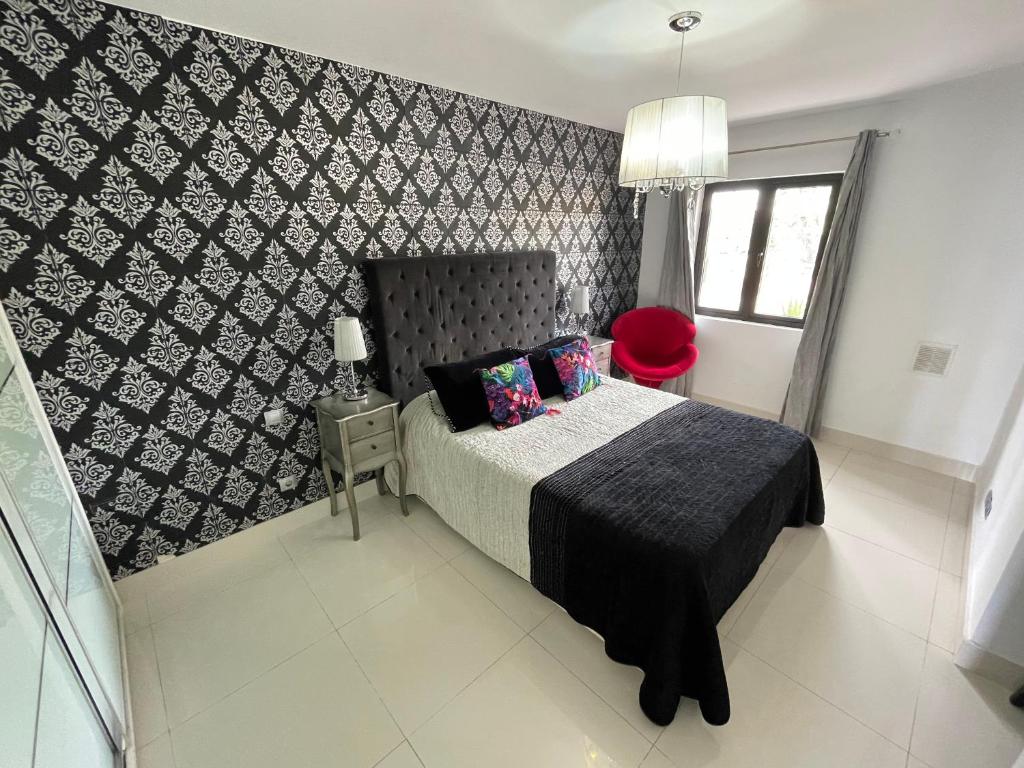 a bedroom with a bed and a black and white wall at Sun club playa del águila by la piedra viva in San Bartolomé