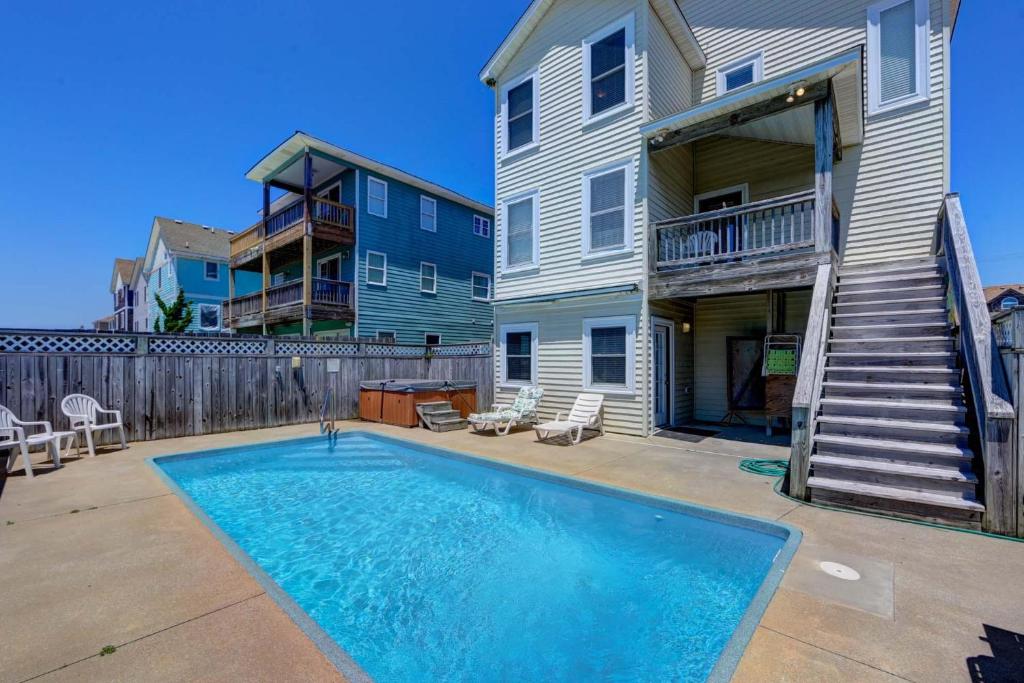 a swimming pool in front of a house at The Sandbox in Kill Devil Hills