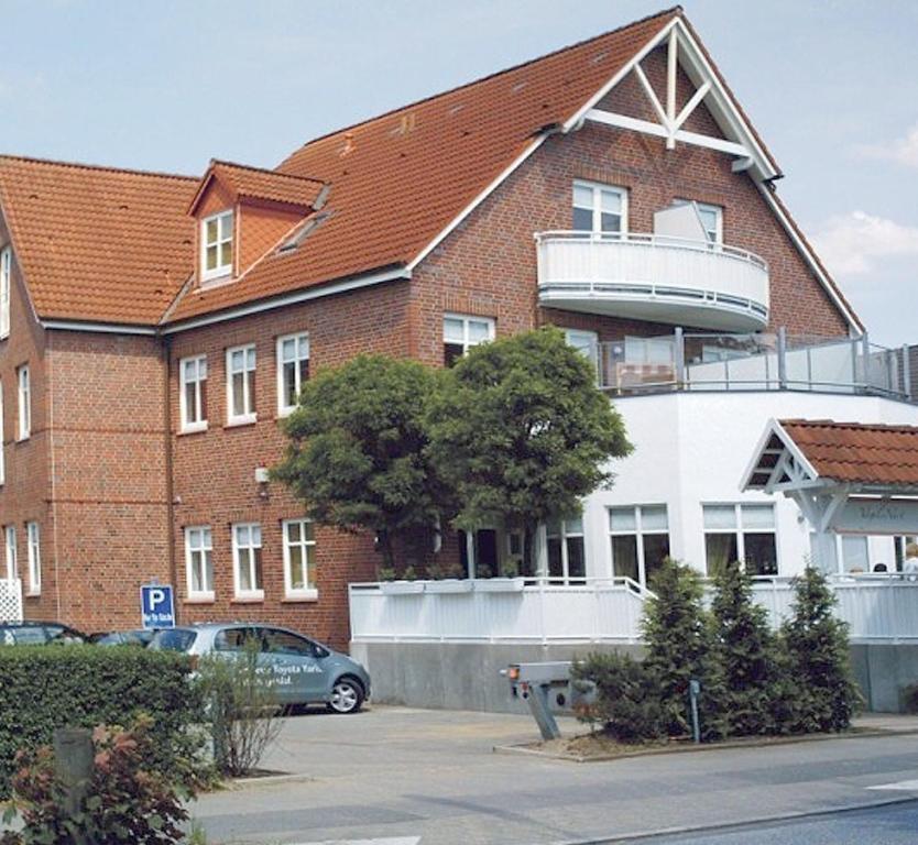 a building with a car parked in front of it at Das Nest Boardinghouse Hamburg Niendorf in Hamburg