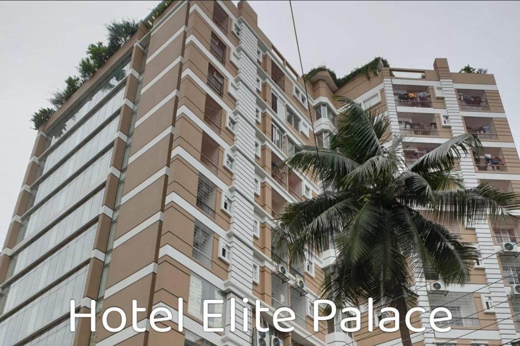 a tall building with a palm tree in front of it at Hotel Elite Palace in Comilla