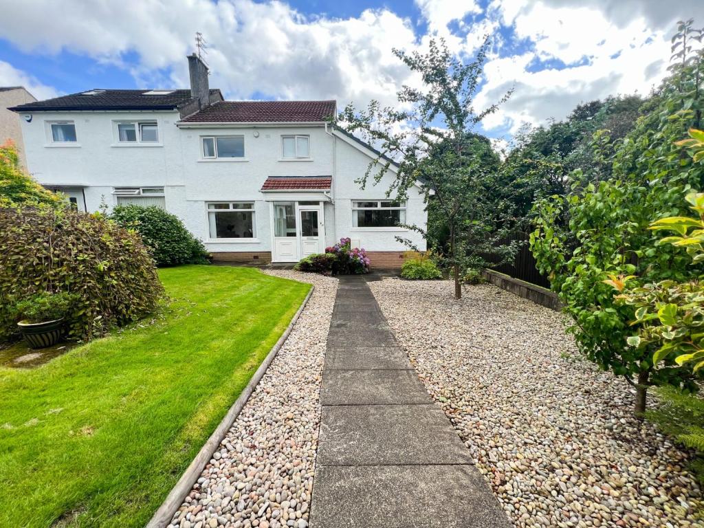 a white house with a gravel driveway at Home away from home Milngavie in Milngavie