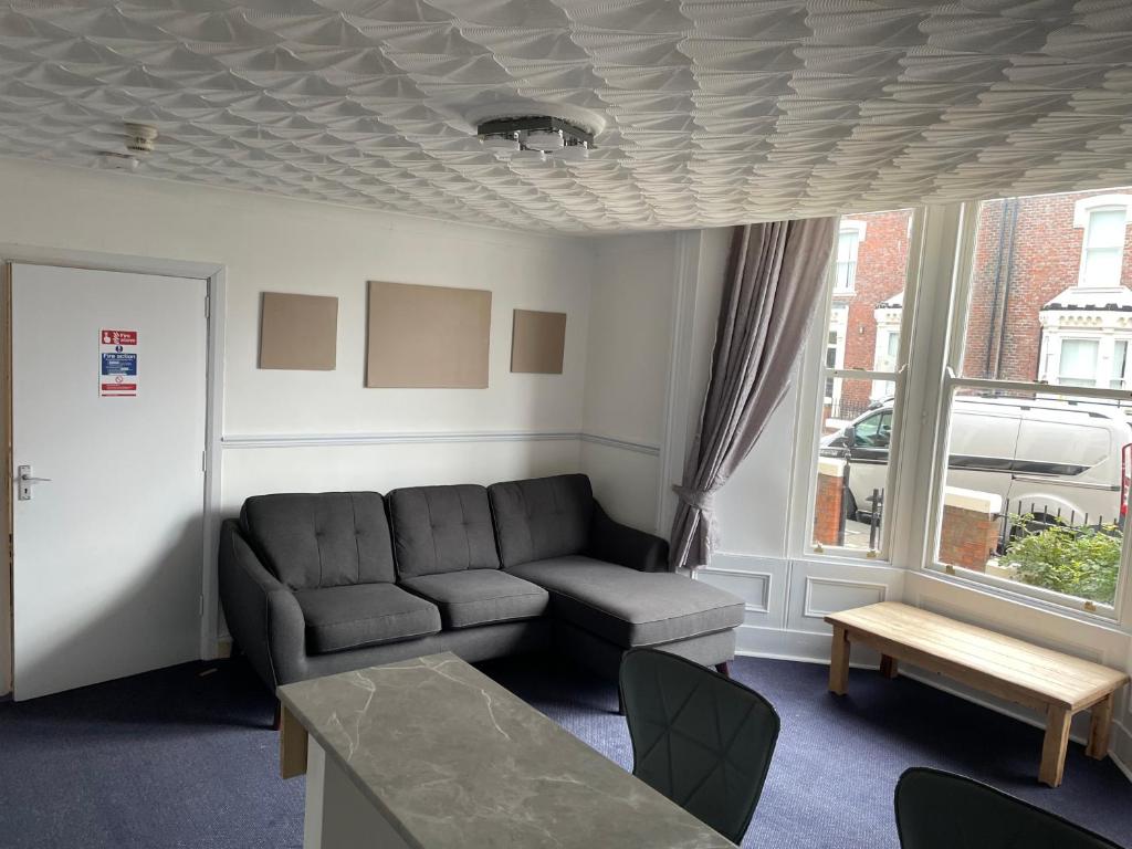 a living room with a couch and a window at Apartments Azalea Terrace in Sunderland