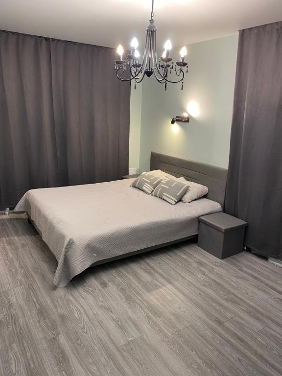a bedroom with a large bed and a chandelier at Platform Narva in Narva