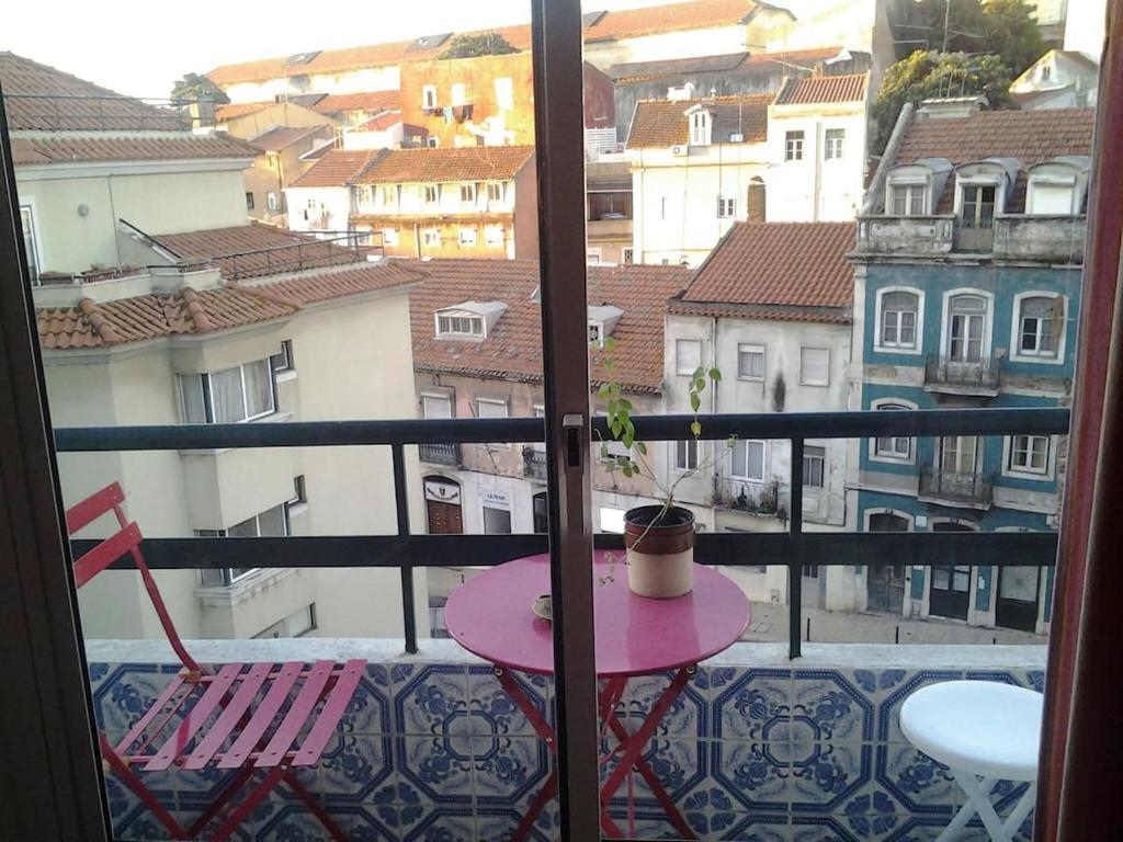 リスボンにあるThe country in the townのピンクのテーブルとバルコニー(椅子2脚付)