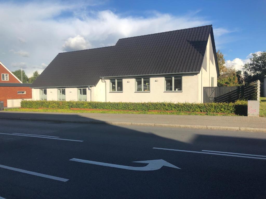 a white house with two arrows on the road at A-Bed in Esbjerg