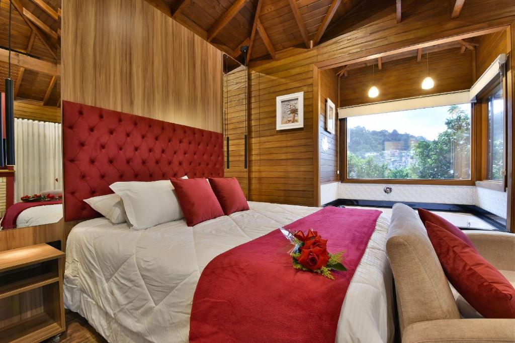 Schlafzimmer mit einem großen Bett mit einem roten Kopfteil in der Unterkunft Stillo Gramado Dutra in Gramado