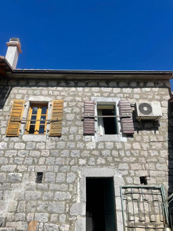 an old stone building with shuttered windows on it at Queen’s vintage house in Podgorica