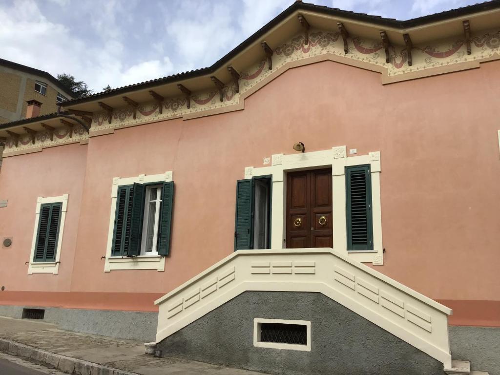 uma casa cor-de-rosa com um alpendre e uma porta em Nel Giardino di Ester B&B em Barile