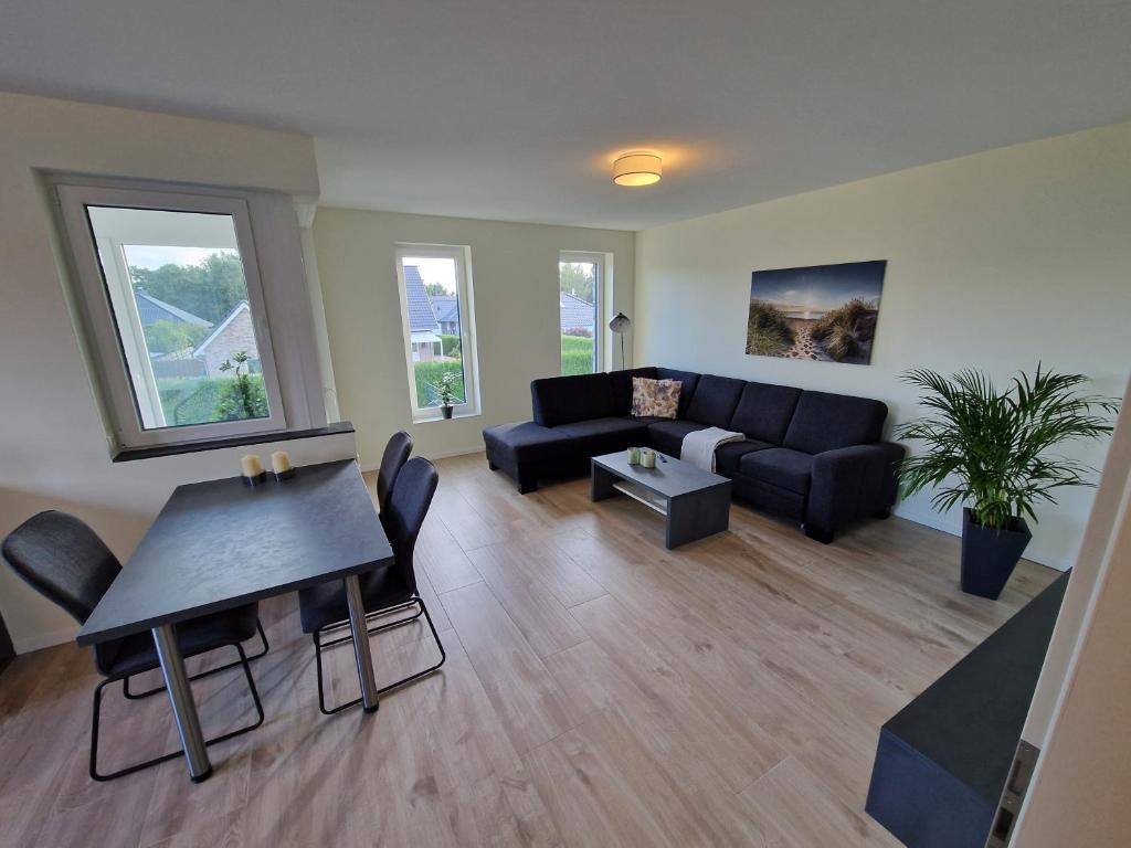 ein Wohnzimmer mit einem Sofa und einem Tisch in der Unterkunft Apartment nahe Meyer Werft in Ostfriesland mit Küche & Netflix in Westoverledingen