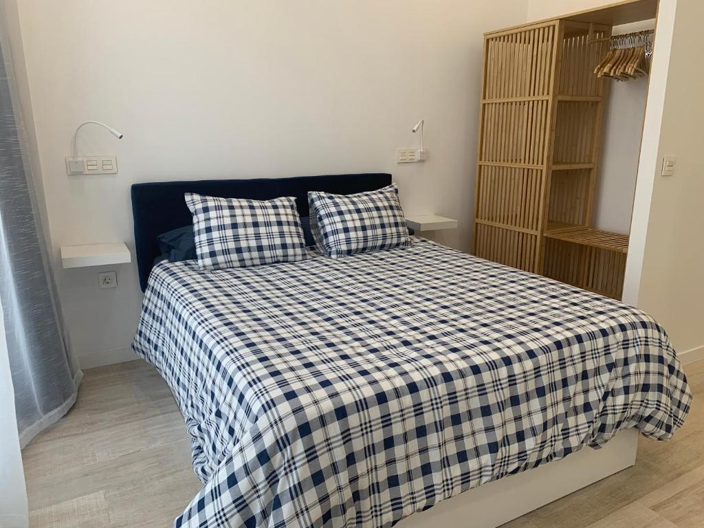- une chambre avec un lit et une couverture en damier dans l'établissement MonKeys Apartments Pagés del Corro Triana, à Séville